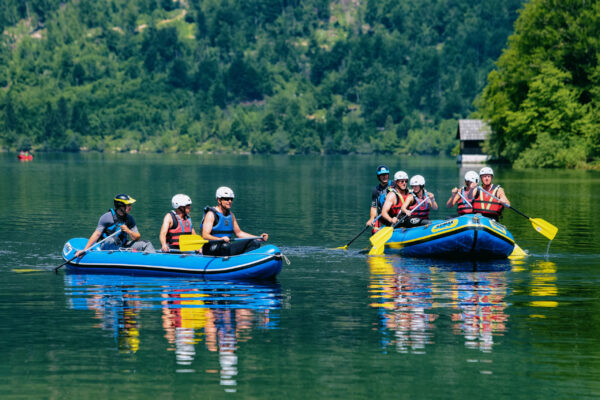 Bohinj, Slovenia - June 3, 2019: Scenery of man canoeing at Bohinj Lake in Slovenia. Nature and people kayaking on water in Slovenija. Beautiful landscape view in summer. Alpine Julian Alps mountains